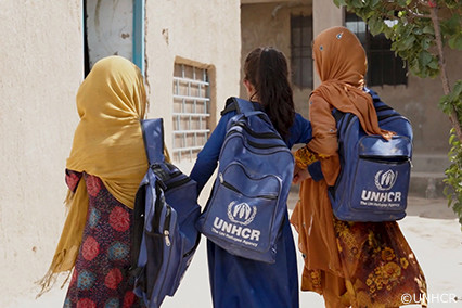 UNHCRのバッグを背負う少女たち