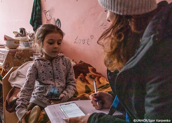 避難民の子どもとUNHCR職員